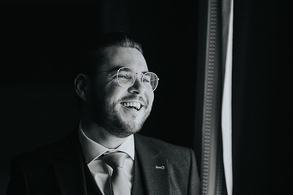 Jon adjusting his cufflinks with a smile.